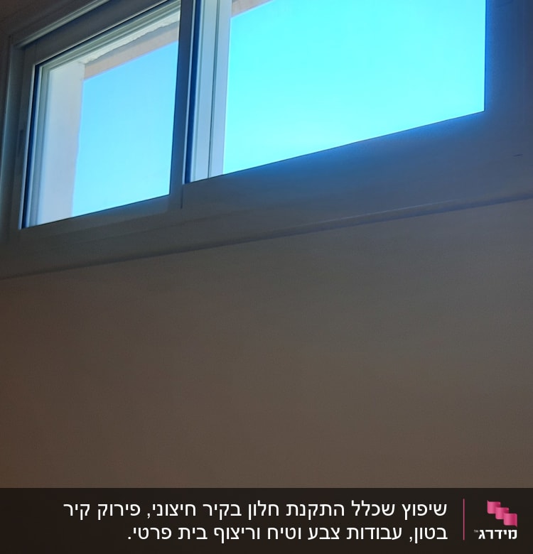 חלון חדש עם מסגרת לבנה על קיר צבוע